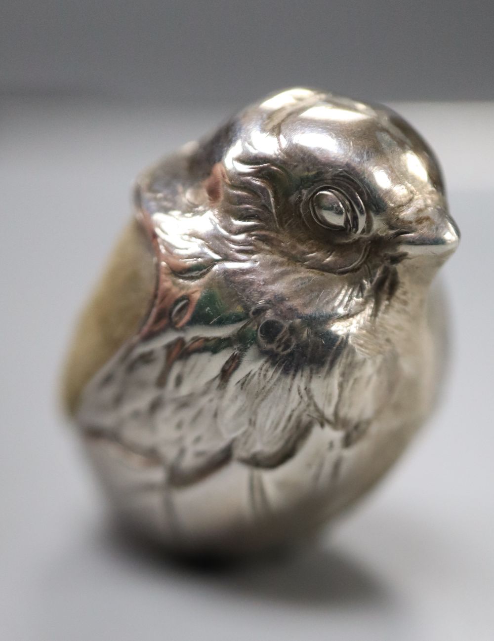 An Edwardian silver mounted hatching duckling pin cushion, Birmingham, 1908, 23mm and two modern silver pin cushions.